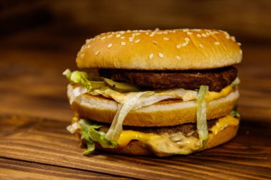 Ahşap masada lezzetli büyük hamburger.