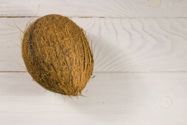 Beyaz ahşap masada hindistan cevizi var. Üst görünüm