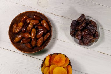 Kurumuş kayısılar ve beyaz ahşap masada meyveler. Üst görünüm