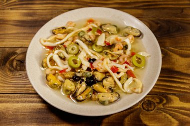 Tahta masada karides, mürekkep balığı ve midye ile deniz ürünleri salatası.