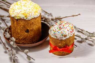 Beyaz ahşap masada kedi söğüt dalları ile Paskalya kek