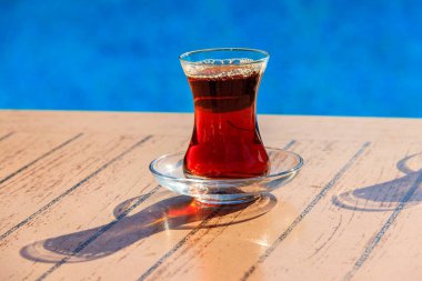 Yüzme havuzunun yanındaki masada sıcak Türk çayı