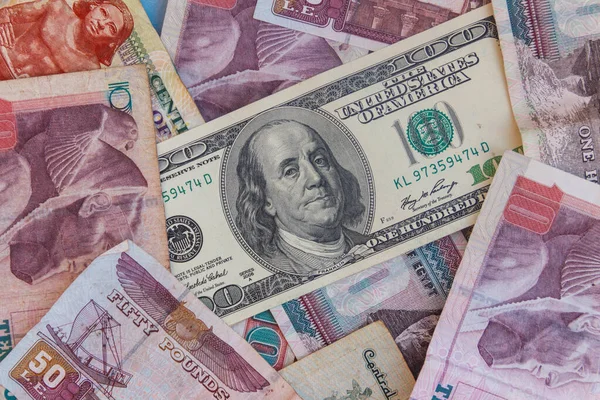 背景为埃及镑钞票的100美元钞票 — 图库照片