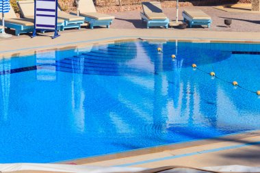 Yüzme havuzunun yanında şezlonglar. Spa, dinlenme, rahatlama, tatil, tatil
