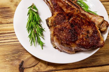 Biberiyeli biftek ve beyaz tabakta ahşap masa.