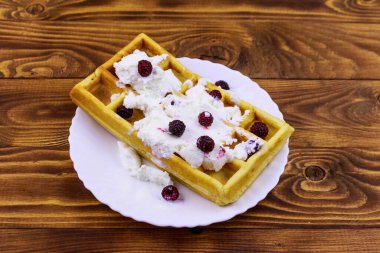 Dondurmalı Belçika waffle 'ı ve ahşap masada böğürtlen