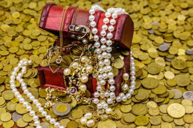 Altın sikke ve mücevherlerle dolu eski bir hazine sandığı.