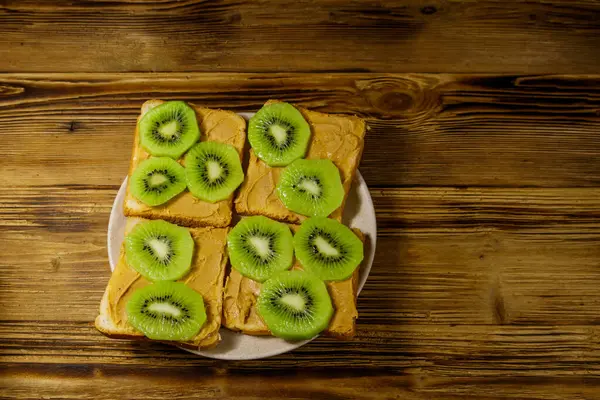 Fıstık Ezmeli Ahşap Masada Kivi Meyveli Lezzetli Sandviçler Üst Görünüm — Stok fotoğraf