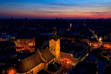 Ukrayna, Lviv 'deki Aydınlatılmış Latin Katedrali ve Rynok Meydanı' nın gece görüşü. Lviv belediye binasından görüntü