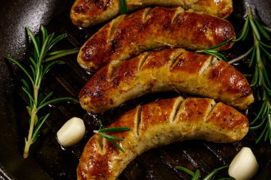 Kızarmış sosis, biberiye, sarımsak ve baharatlı dökme demir ızgara kızartma tavası.