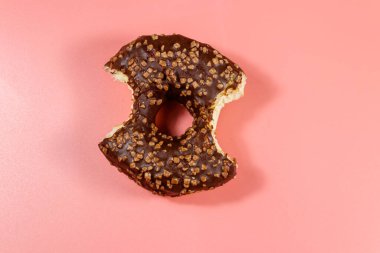 Pembe arka planda lezzetli çikolatalı donut. Üst görünüm