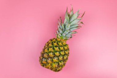 Pembe arka planda koca bir ananas. Üst görünüm