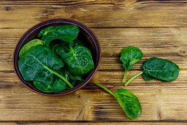 Tahta bir masada taze yeşil ıspanak yaprakları. Üst görünüm