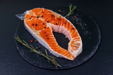 Siyah tahtada baharatlı çiğ somon bifteği.