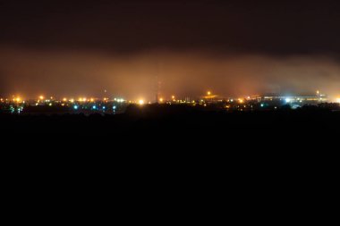 Şehrin sanayi bölgesinin gece görüşü ve fabrika boruları.