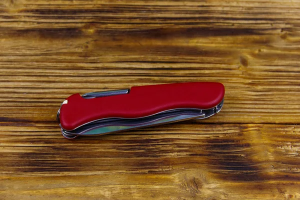 Красный Универсальный Карманный Нож Деревенском Деревянном Фоне Вид Сверху — стоковое фото