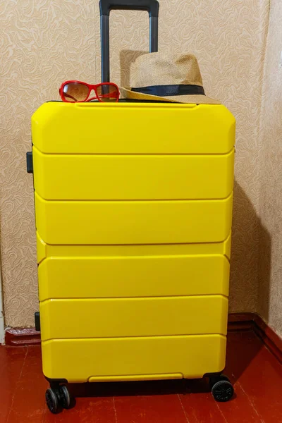 部屋にサングラスと帽子付きの黄色のスーツケース 旅行のコンセプト — ストック写真