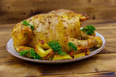 Ahşap bir masada bütün tavuğu patates ile pişirdim.