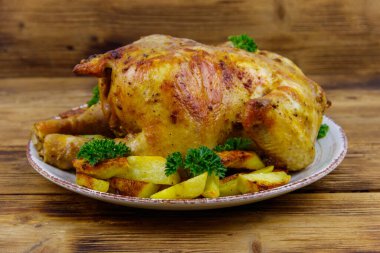 Ahşap bir masada bütün tavuğu patates ile pişirdim.