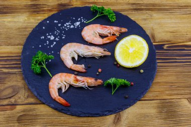 Tahta tahtada limonlu, maydanozlu, tuzlu ve biberli büyük çiğ karidesler