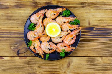 Tahta masada limonlu ve maydanozlu kırmızı haşlanmış karides. Üst görünüm