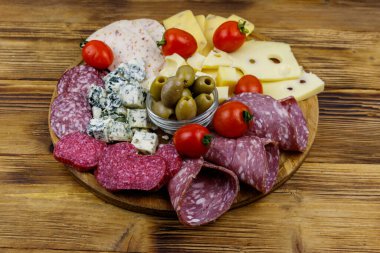 Zeytinli, kiraz domatesli, ahşap bir masada İtalyan salamı ve peyniri karışımı.