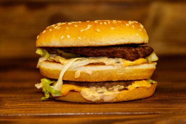 Ahşap masada lezzetli büyük hamburger.