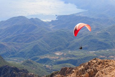 Türkiye 'nin Antalya ilinin Kemer ilçesi yakınlarındaki Tahtali dağının tepesinden paraşütçüler uçuyor. Aktif yaşam tarzı ve ekstrem spor macerası kavramı
