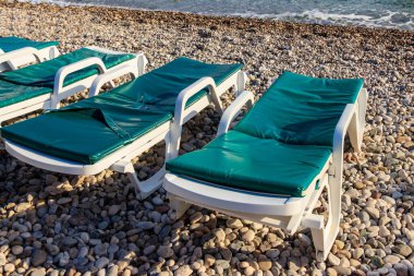 Çakıl taşı plajındaki şezlonglar. Dinlenme, rahatlama, tatil, tatil