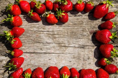 Taze kırmızı çilek çerçevesi ahşap masa üstünde fotokopi alanı manzaralı.