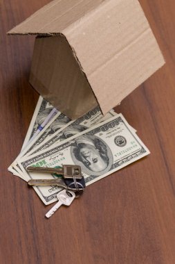 Küçük karton ev, anahtarlar ve paralar ahşap masada. Kredi, ev kredisi. Konut satın alma. Emlak sigortası. Konutun kirası