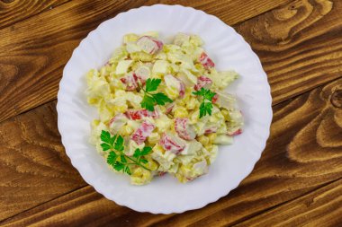 Yengeç saplı salata, tatlı mısır, Çin lahanası, yumurta ve mayonez ahşap masada.