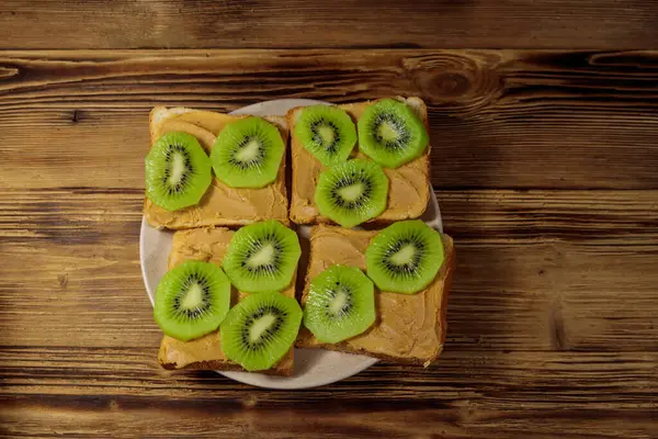 Fıstık Ezmeli Ahşap Masada Kivi Meyveli Lezzetli Sandviçler Üst Görünüm — Stok fotoğraf