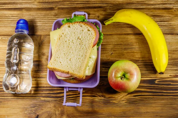 Pranzo Con Panini Bottiglia Acqua Banana Mela Tavolo Legno Vista — Foto Stock