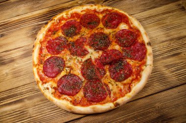 Ahşap bir masada sosis ve peynirli lezzetli taze pizza.