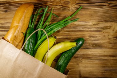 Tahta masa üzerinde farklı yiyecekler olan kağıt torba. Üst Manzara. Market alışverişi kavramı