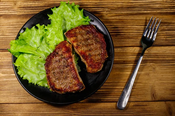 Grillade Fläskbiffar Med Salladsblad Träbordet Ovanifrån — Stockfoto