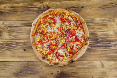 Tahta bir masada nefis taze pizza. Üst görünüm