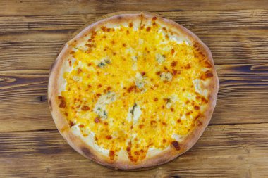 Tahta arka planda dört peynirli pizza. Üst görünüm