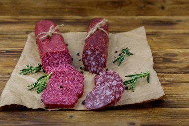 Salamlı sosisler ahşap bir masada kağıt üzerinde.