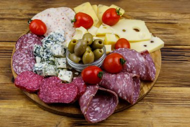 Zeytinli, kiraz domatesli, ahşap bir masada İtalyan salamı ve peyniri karışımı.