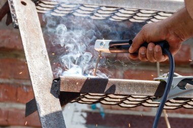 İşçi çeliği elle kaynak yapıyor.