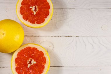Beyaz ahşap masada olgun taze greyfurtlar. Üst görünüm, alanı kopyala