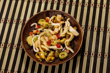 Karides, mürekkep balığı ve bambu hasırlı midye salatası.