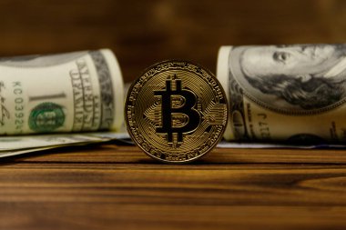 Altın bitcoin ve ahşap arka planda dolar