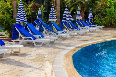 Yüzme havuzunun yanında şezlonglar. Spa, dinlenme, rahatlama, tatil, tatil