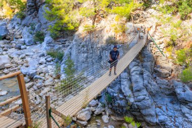 Antalya ilinin Goynuk kanyonunda asma ahşap köprüde duran genç adam, Türkiye