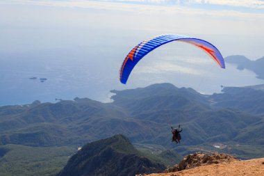 Türkiye 'nin Antalya ilinin Kemer ilçesi yakınlarındaki Tahtali dağının tepesinden paraşütçüler uçuyor. Aktif yaşam tarzı ve ekstrem spor macerası kavramı