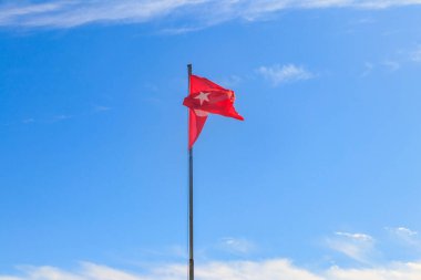 Mavi gökyüzüne karşı Türkiye bayrağı sallıyor