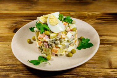 Geleneksel Rus şenlik salatası Olivier tahta masada.